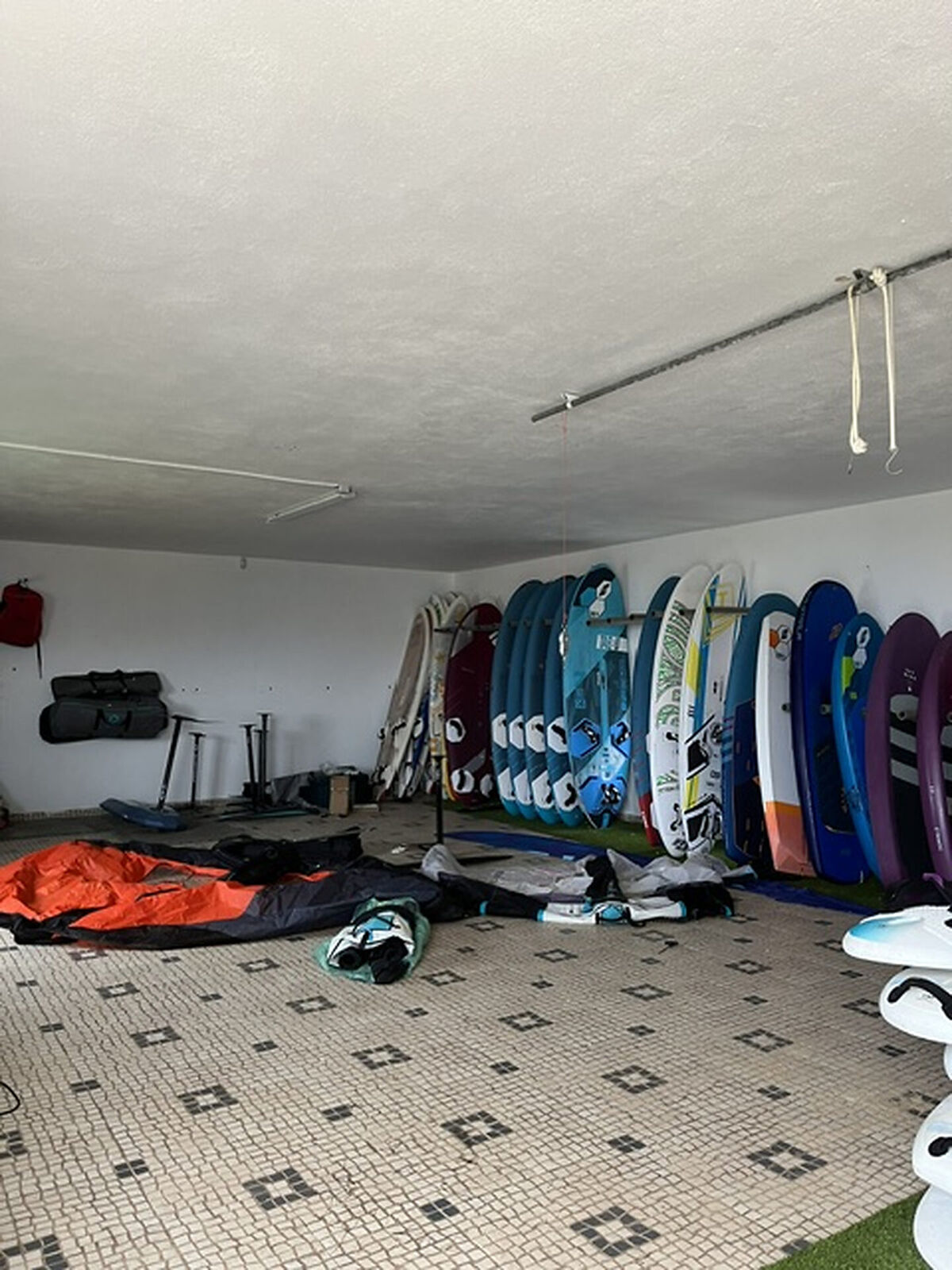 Garaje real antes de la propuesta, con tablas de surf y material deportivo