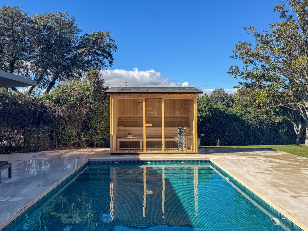 Sauna de exterior a medida junto a una piscina
