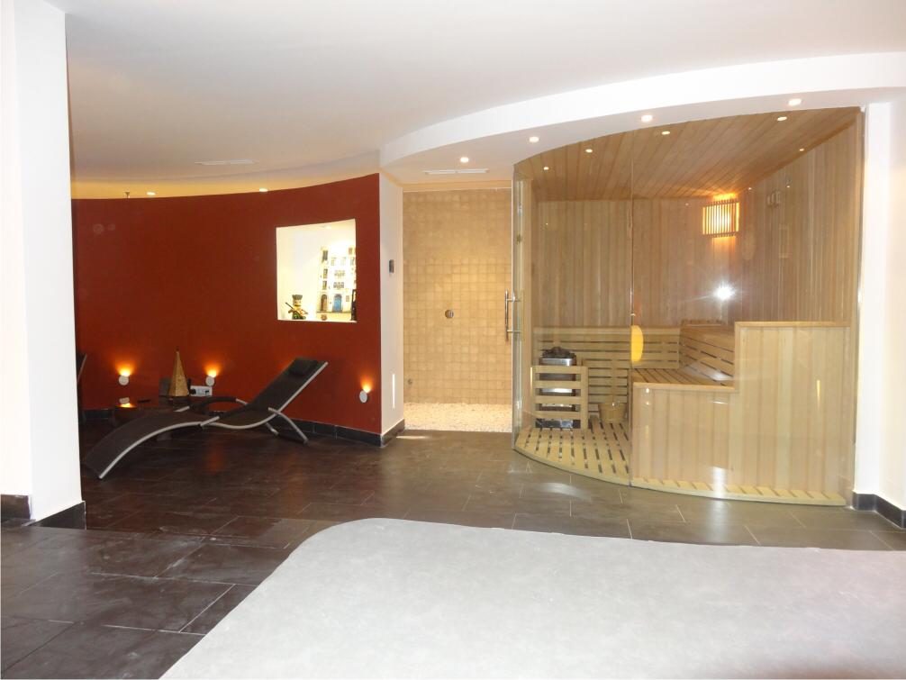 Sauna finlandesa acristalada con bancos de madera y calefactor de piedras